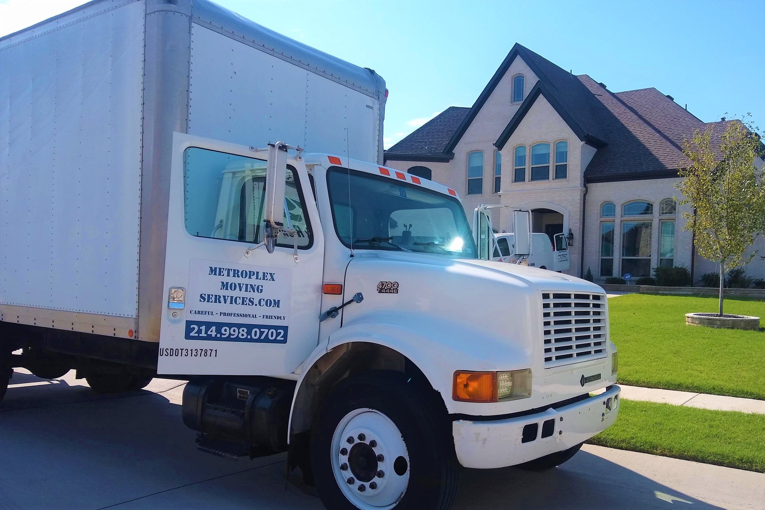Metroplex Moving Services truck in front of house